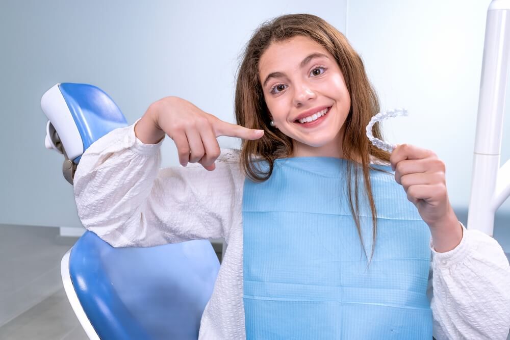 teen girl in white shirt lying at dentist clinic with aesthetic orthodontics invisalign