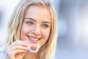 Young attractive woman holding using invisible braces