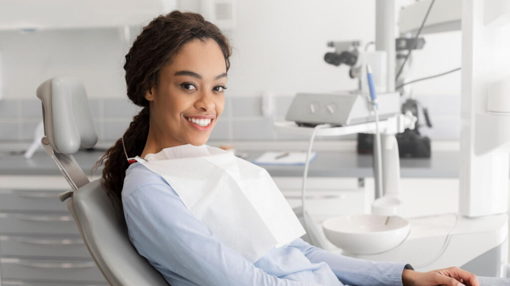 Young lady sitting in dentist chair and smiling