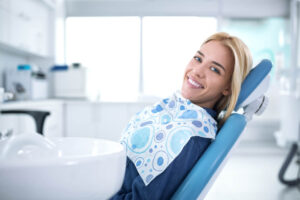 Smiling and satisfied patient in a dental office after treatment