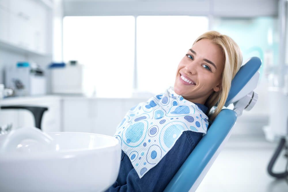 Smiling and satisfied patient in a dental office after treatment