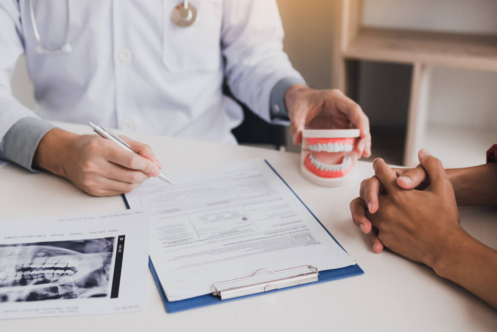 male dentist hand holding pen writing patient history list on note pad.