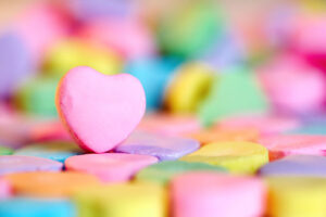 Empty pink heart candy over colorful bonbon