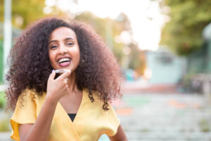 Beautiful smiling African black woman is holding invisaligner