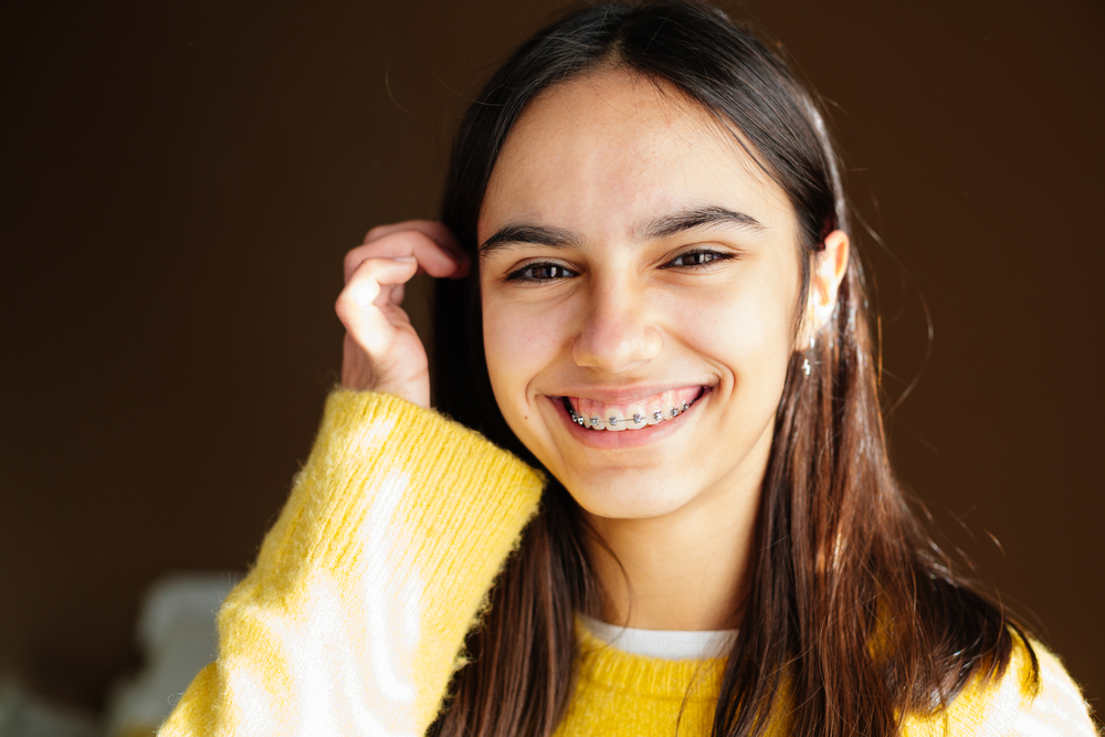 A Happy Teen Girl With Braces after receiving Teen Orthodontics