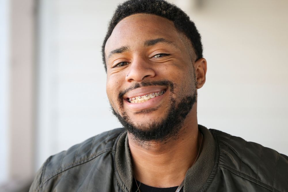 A young man smiling with his metal braces