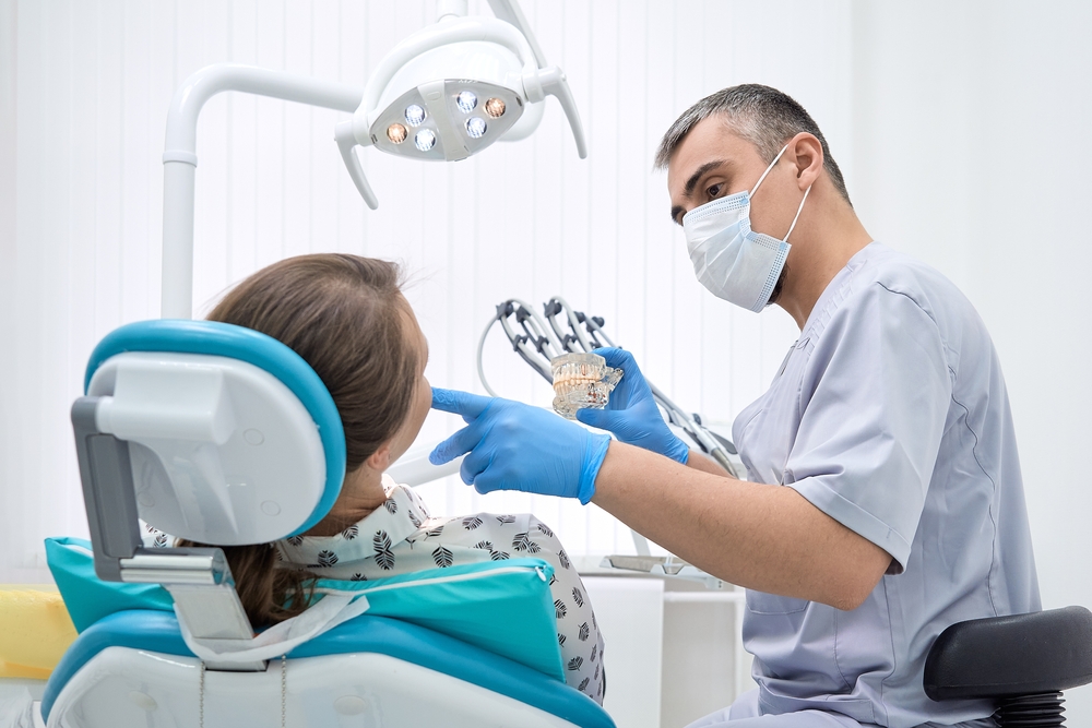An orthodontist conducts a consultation on dental prosthetics.