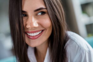 Close up portrait of sweet nice person smiling toothy with shiny veneers in comfy house living room flat