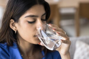 young woman make sip, drinking glass of water, staying hydrated enjoying peaceful moment of refreshment