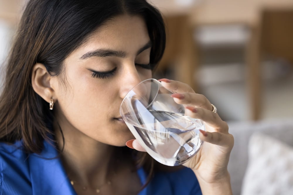 young woman make sip, drinking glass of water, staying hydrated enjoying peaceful moment of refreshment