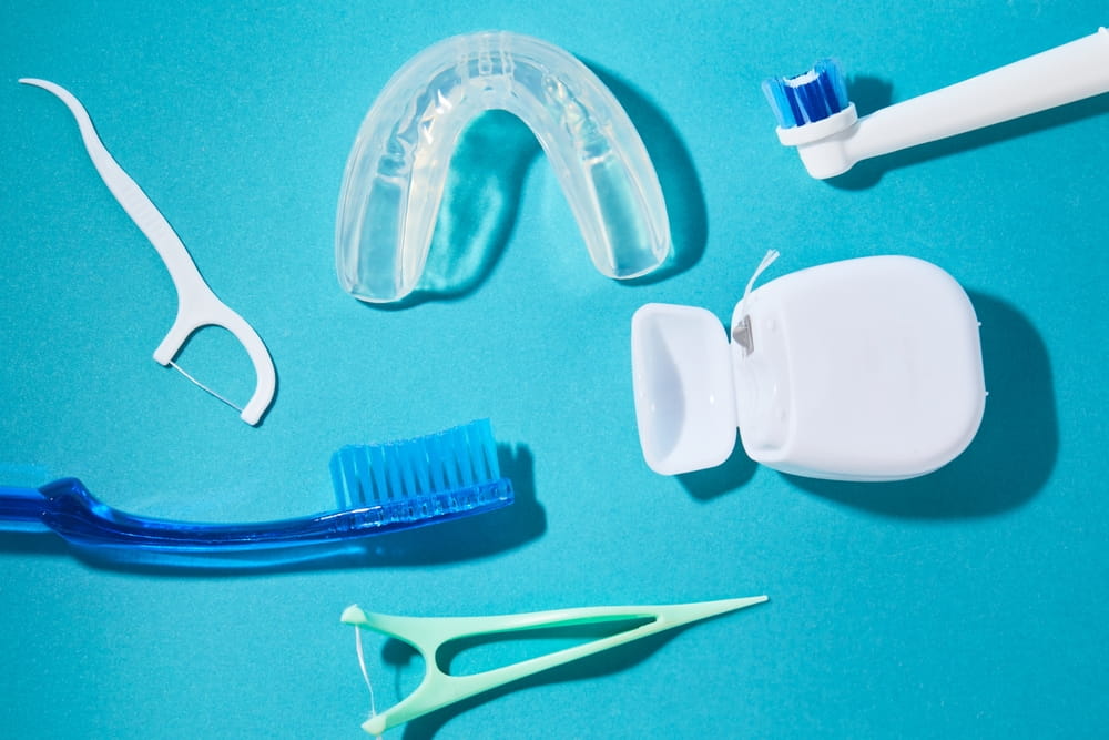 Set with oral care tools on a blue background. Dental floss, toothpicks and brushes hygiene products Kit.