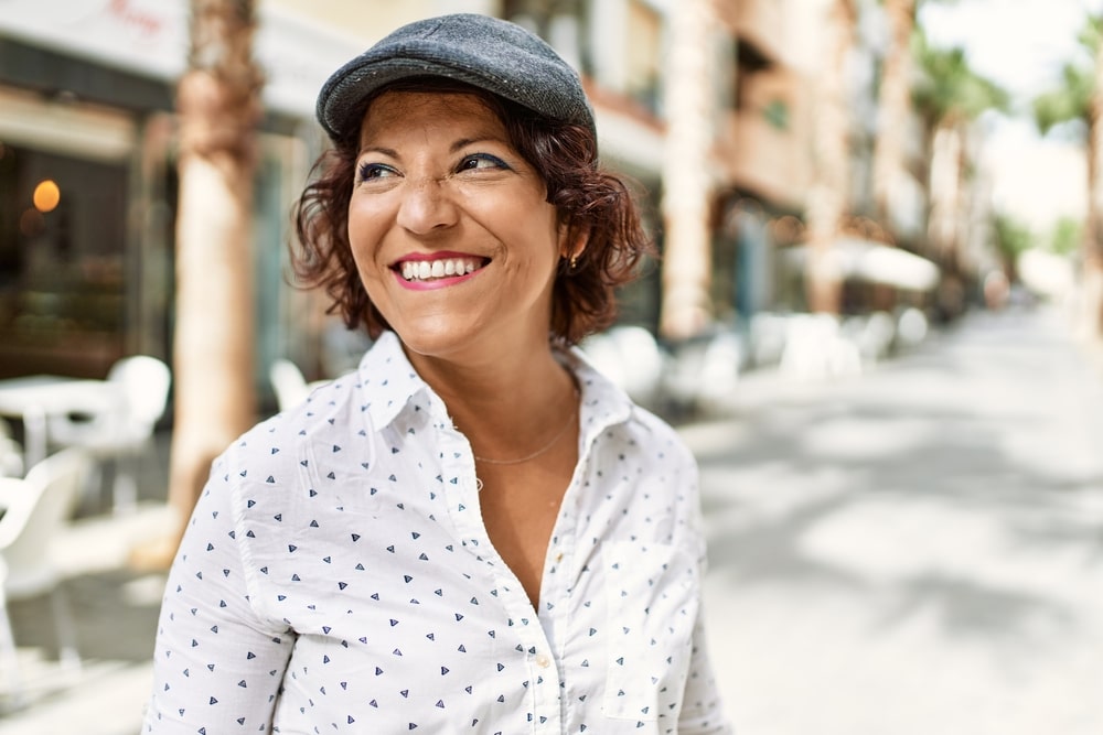 Middle age latin woman smiling happy standing at the city.