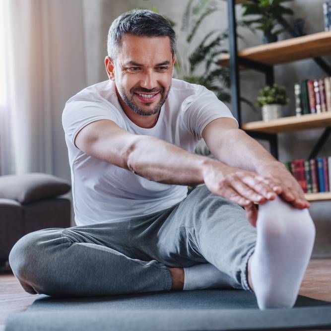 man doing hamstring stretch exercise at home