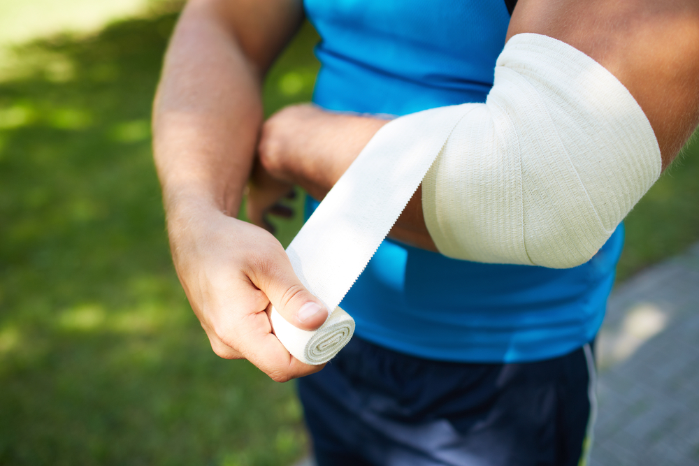 male bandaging his arm