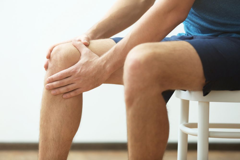 Young man suffering from knee pain