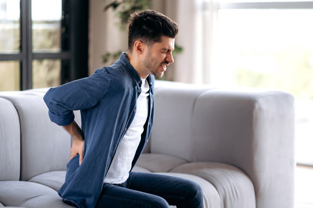 adult bearded man suffering from back pain