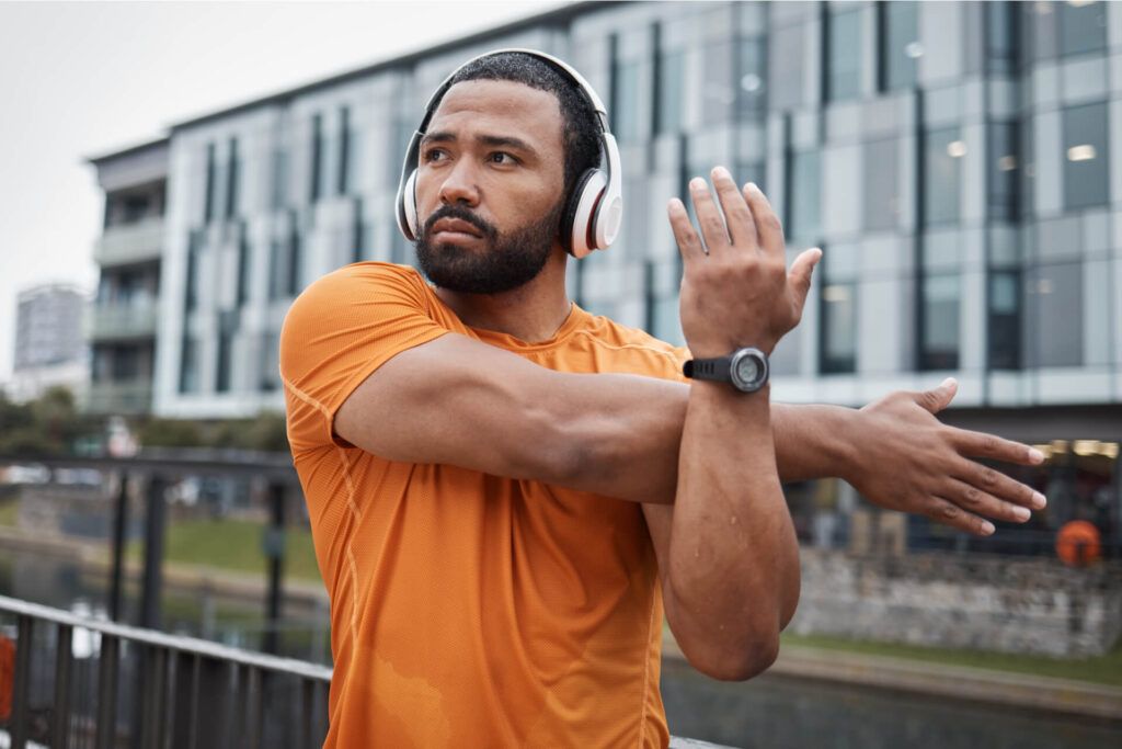 Fitness, runner or black man stretching in city for running training