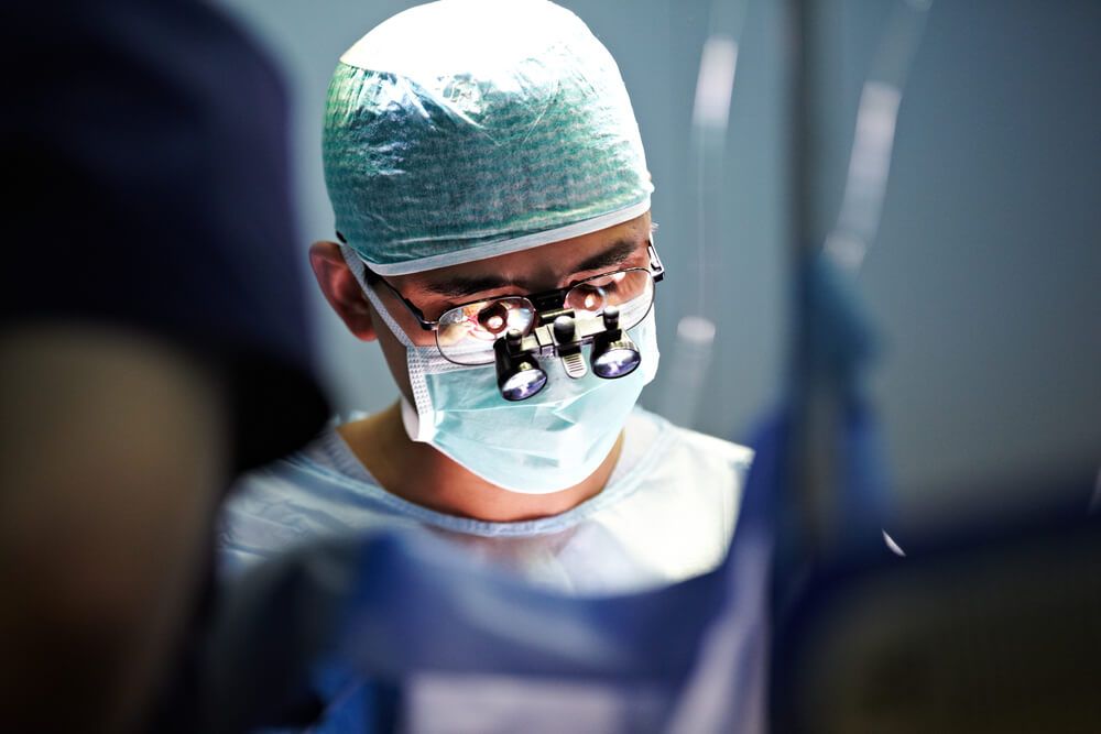 Unrecognizable surgeon performing operation, operation theater