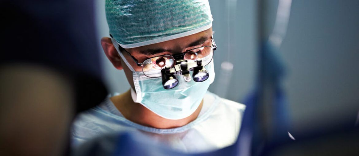 Unrecognizable surgeon performing operation, operation theater