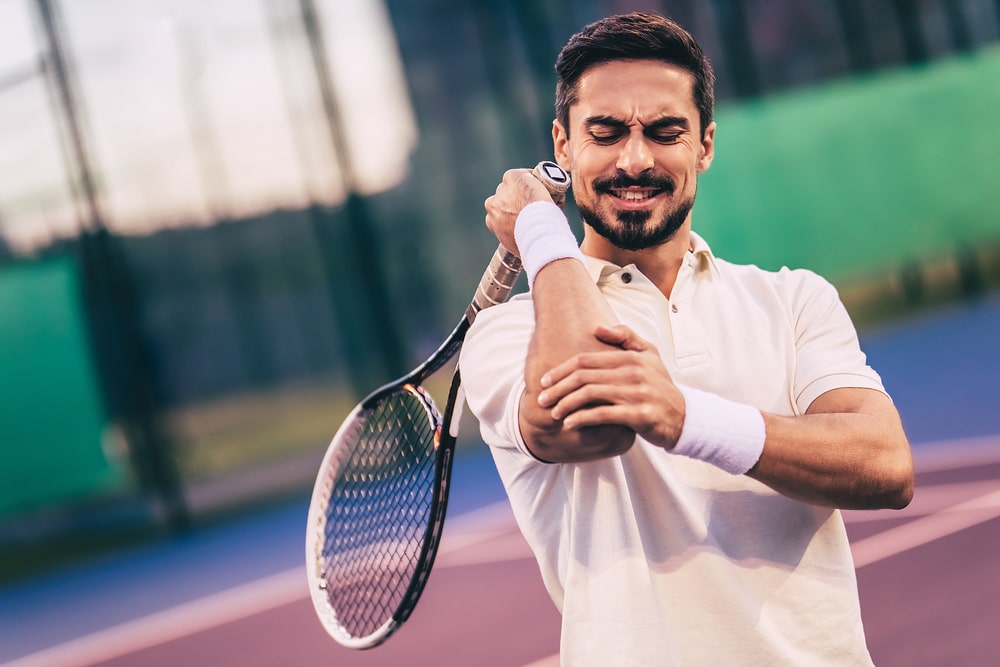 Man Playing Tennis and Elbow Hurting