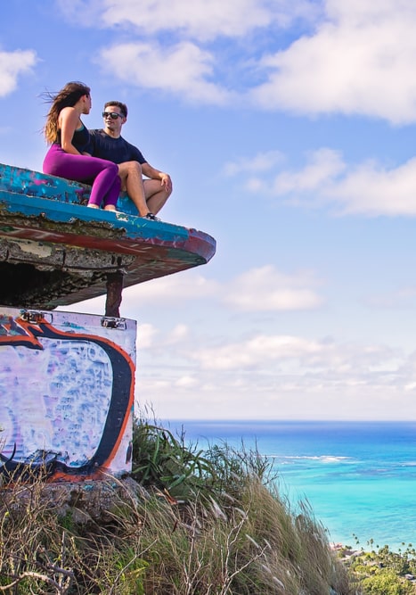 Young beautiful couple sitting on pillbox