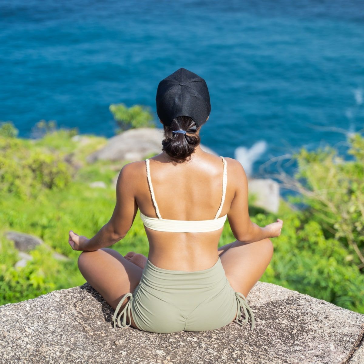 woman meditating on the cliff of mountain