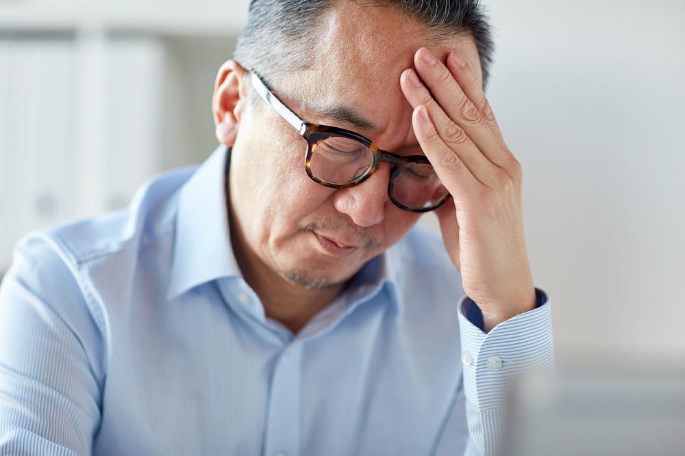 man in eyeglasses suffering from headache