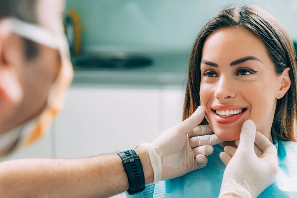 Young smiling woman with beautiful teeth, having a dental inspection