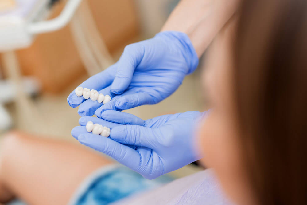 Dentist showing porcelain crowns to the patient.