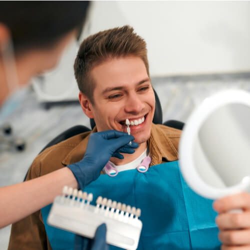 closeup of a dentist with tooth color samples