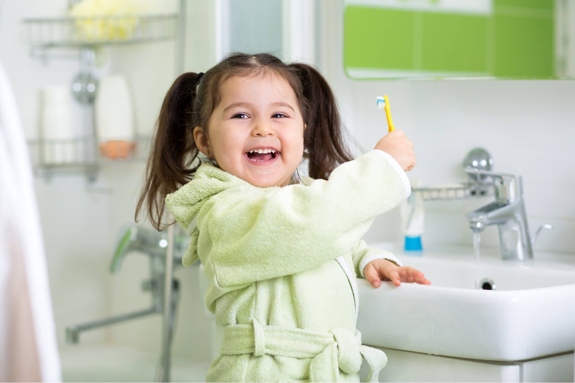 Cute child girl brushing teeth in bathroom