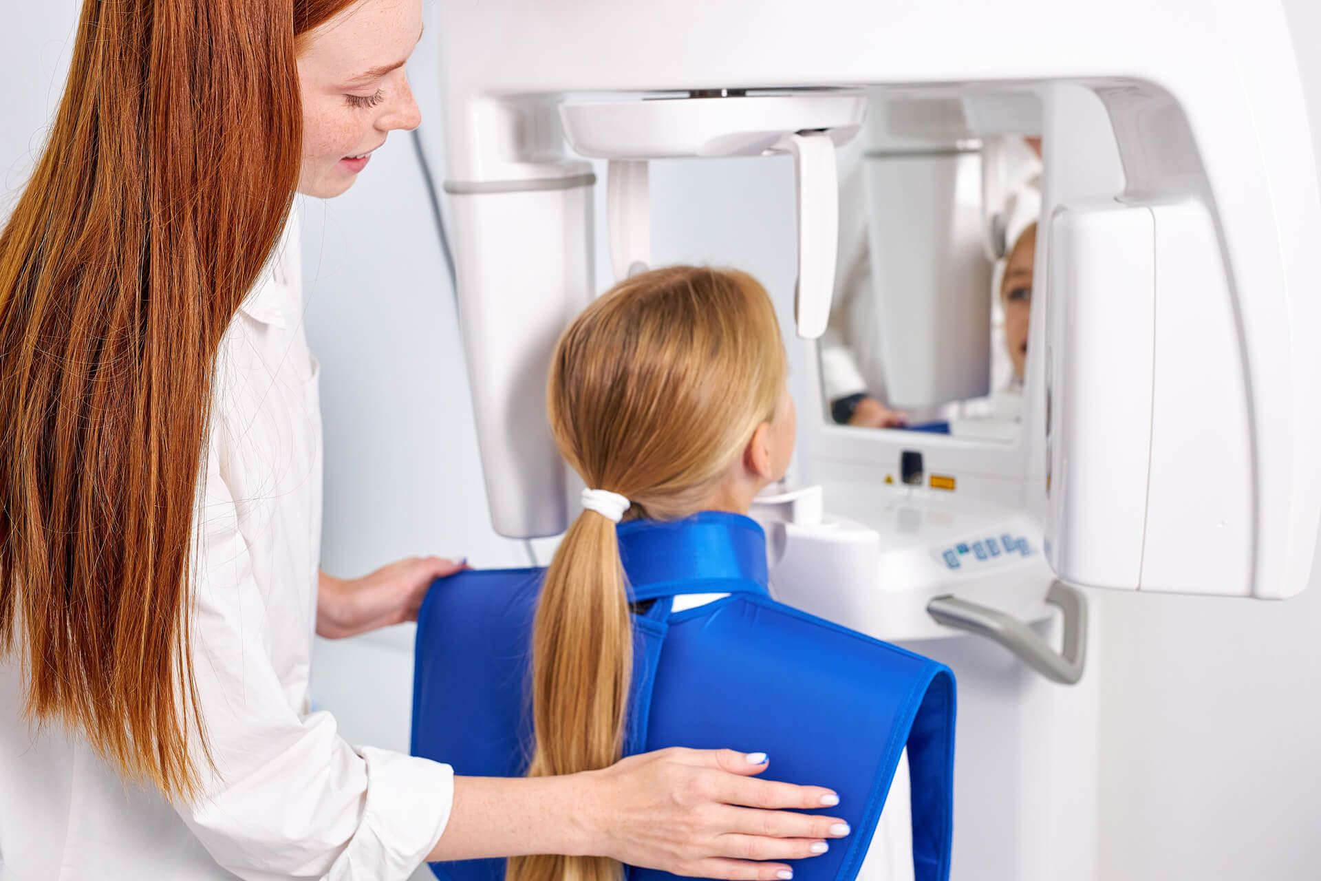 Woman dentist taking teeth x-ray of beautiful child