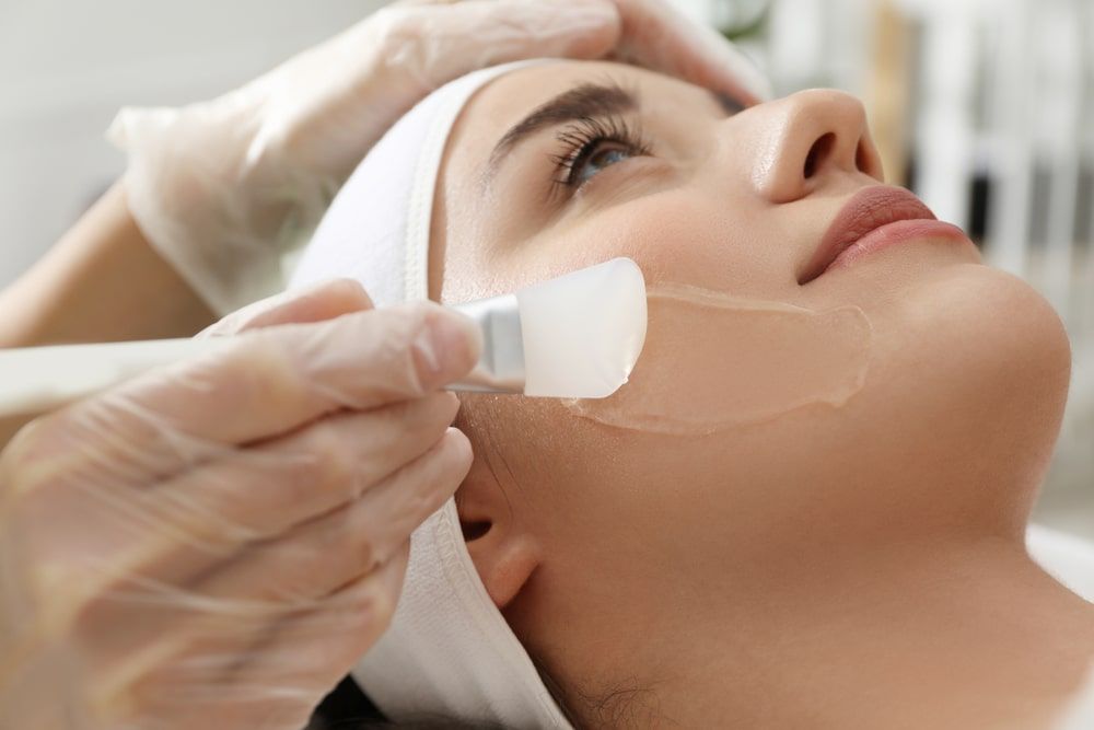 Young woman during face peeling procedure in salon