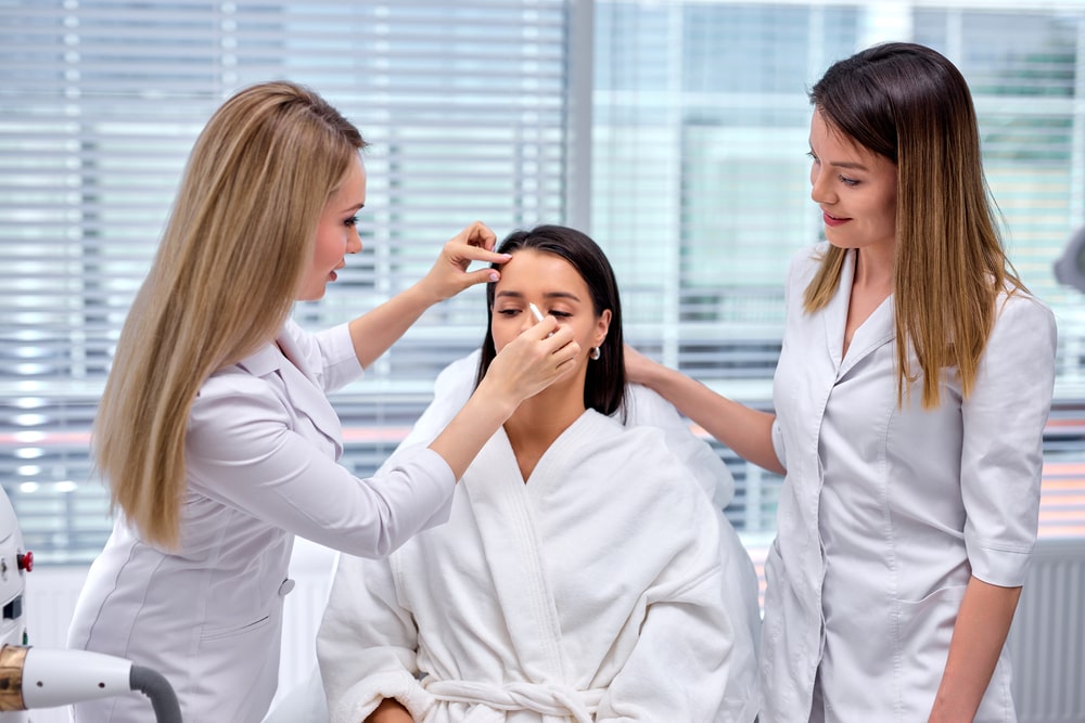 doctor drawing contour line on female face before fine Thread Lifting,