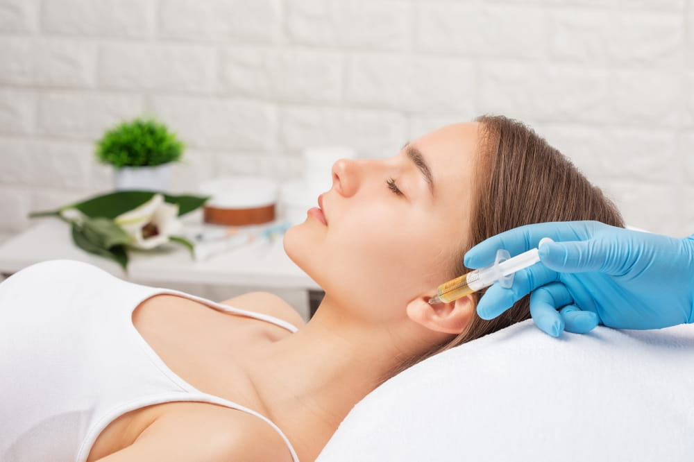 Cosmetologist does prp therapy on the face of a beautiful woman in a beauty salon. Cosmetology concept.