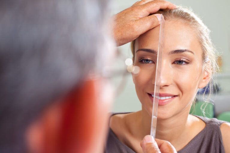 Close-up of female face being measured by plastic surgery doctor