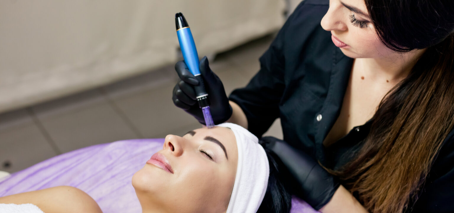 A beautician in a black dressing gown brunette makes mesotherapy injections to a patient