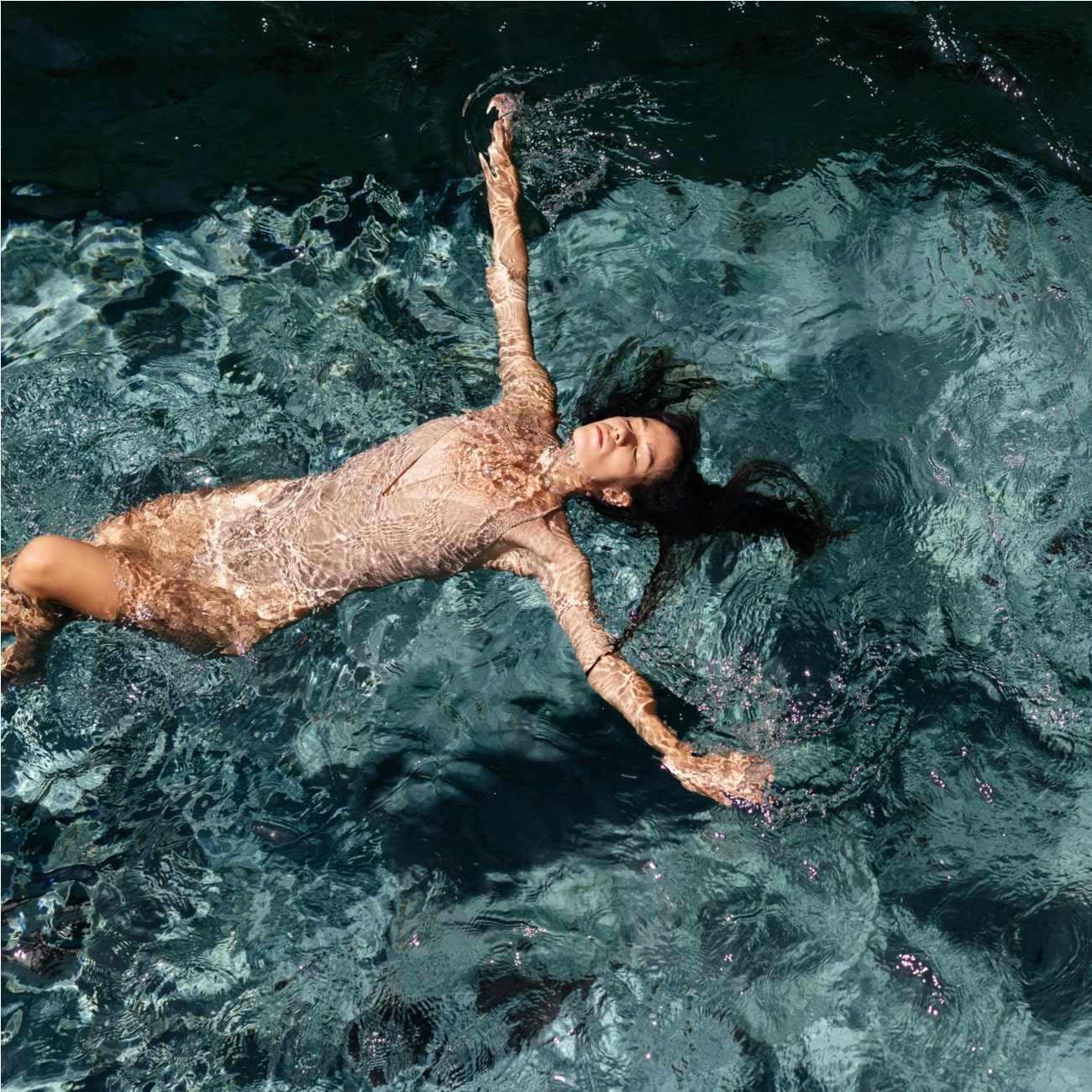 Attractive young woman floating in a swimming pool