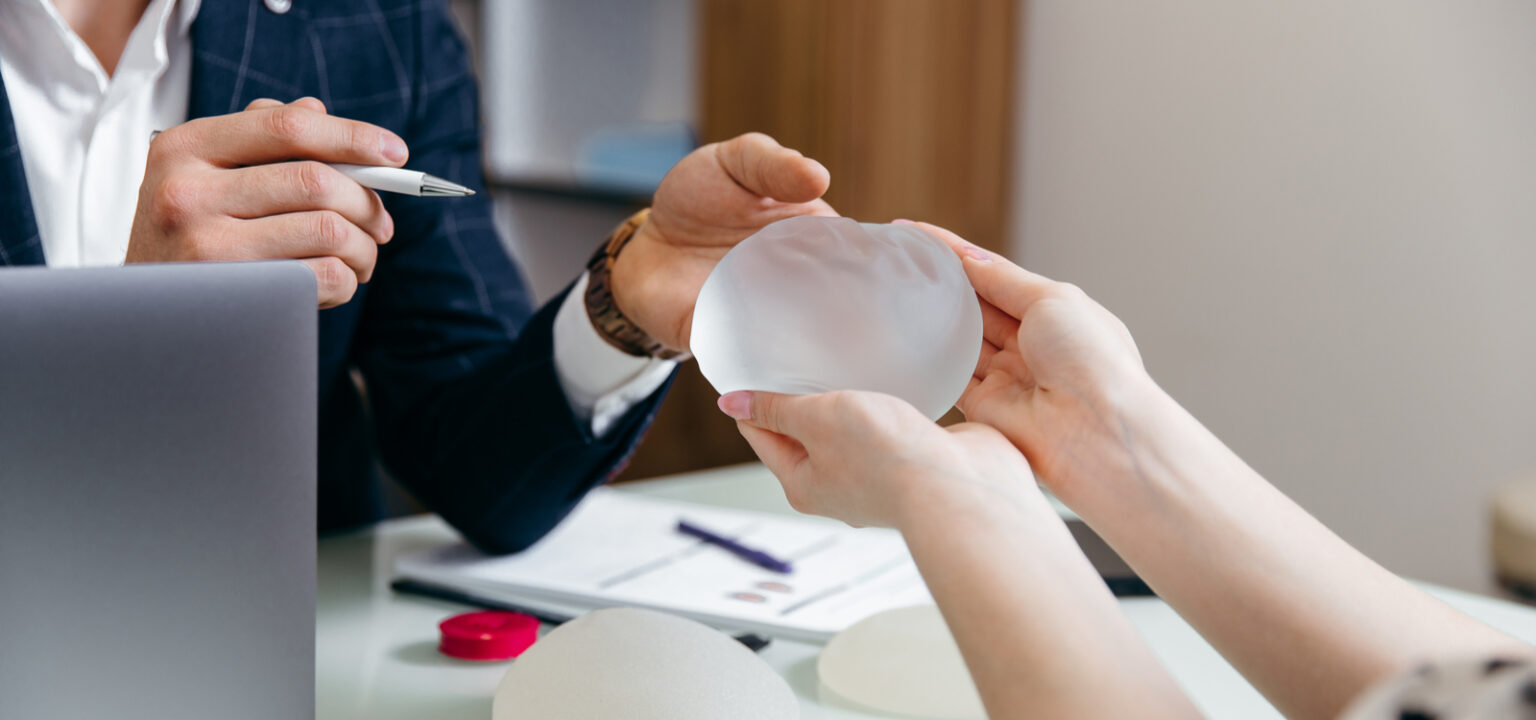 Cosmetic Surgeon Shows Female Patient Breast Implant Samples