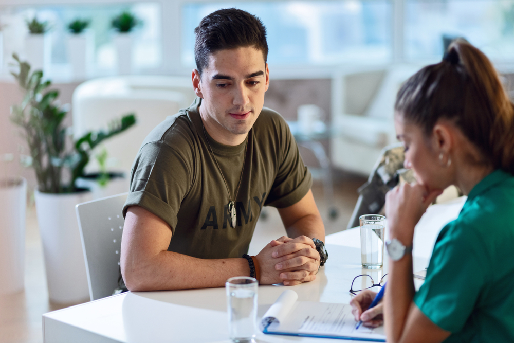 Depressed army soldier seeking for counselling and having a meeting with doctor at clinic.