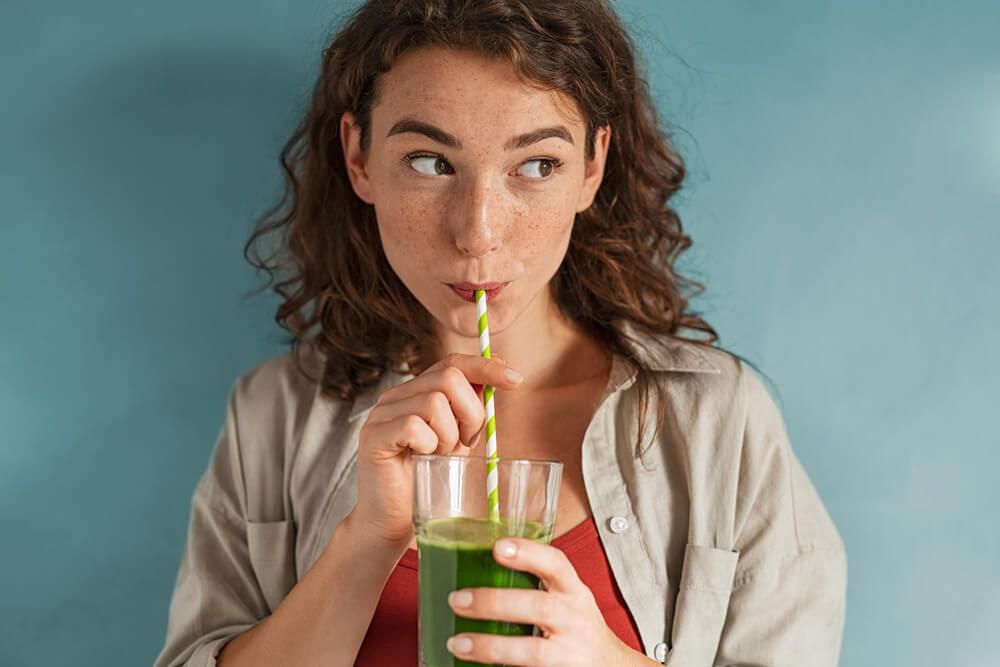 Beautiful woman drinking an organic green smoothie