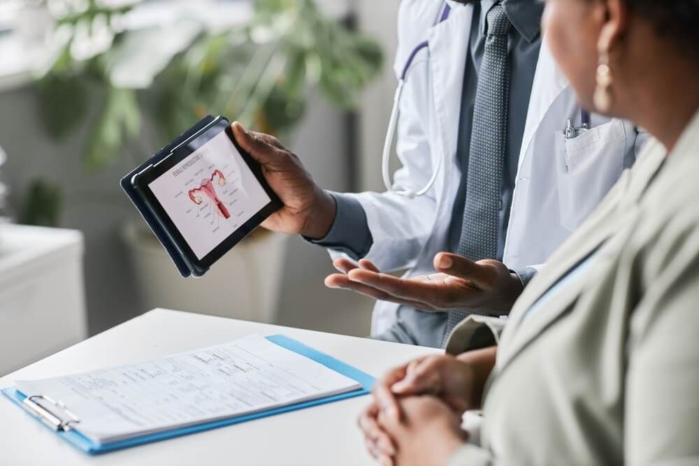 Close up of doctor holding tablet with female reproductive health charts