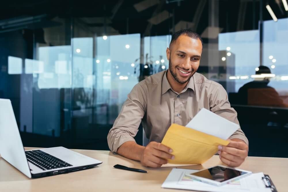 Happy african american businessman financier reading letter from bank