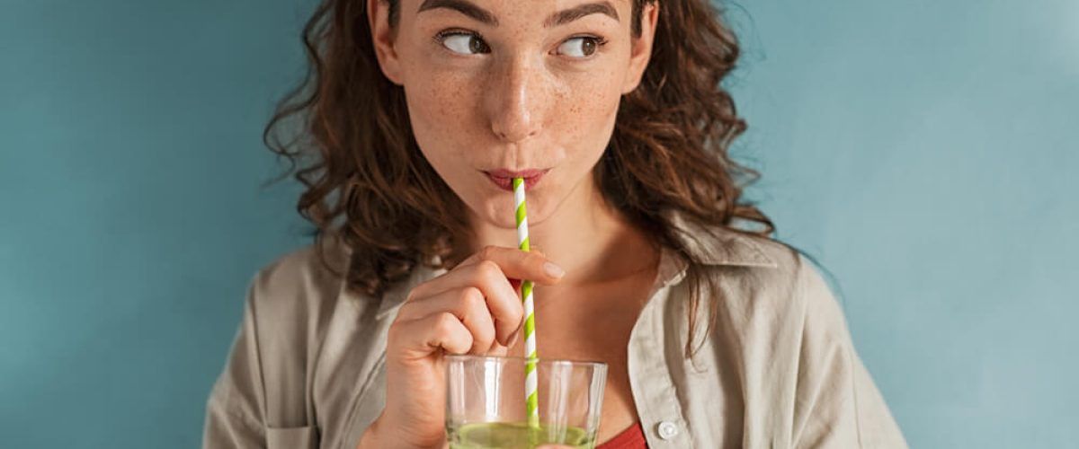 Beautiful woman drinking an organic green smoothie