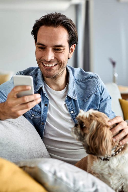 Young happy man text messaging on cell phone