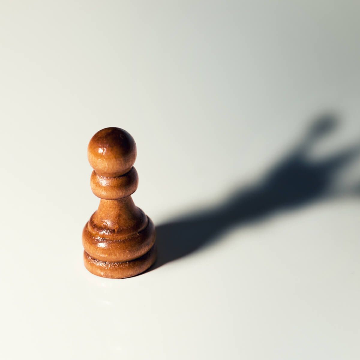 chess pawn with king shadow