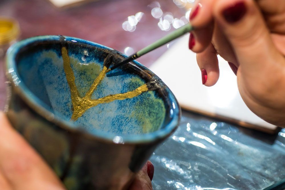 Female hands fixing porcelain with kintsugi method
