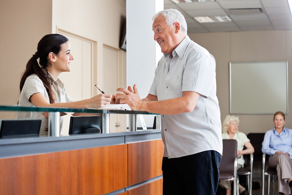 Senior man communicating with female receptionist