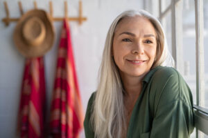 Portrait of beautiful senior woman sitting near big window