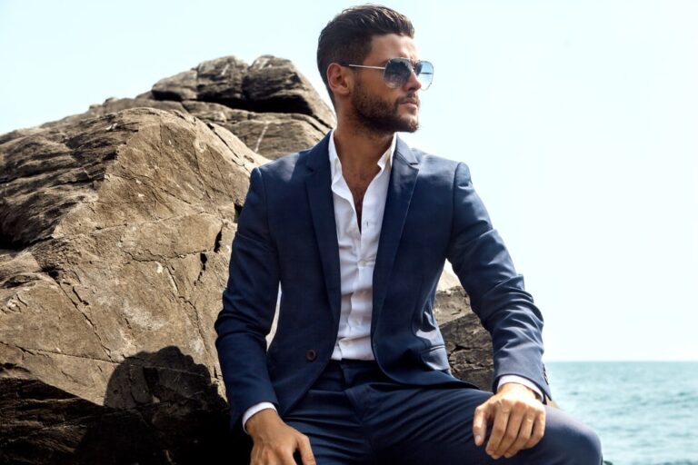 Man in elegant suite posing in rock background